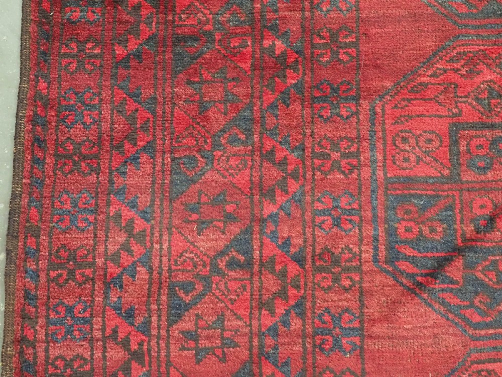 A large antique hand-knotted Afghan Ersari wool carpet featuring repeating octagonal gul patterns on a deep red field. View VII