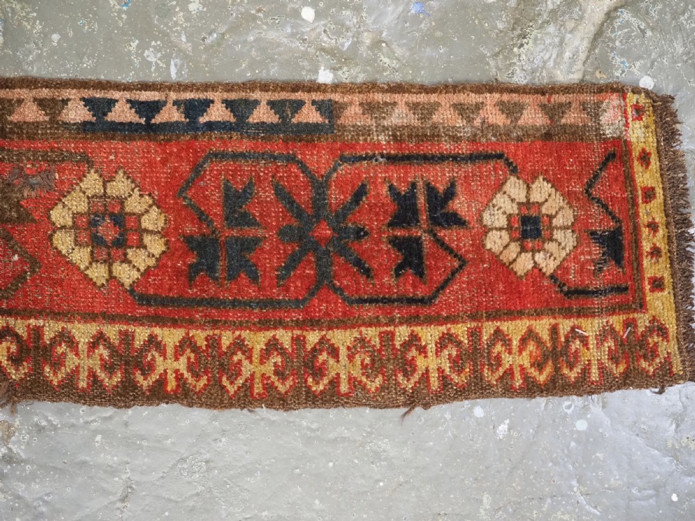 A long, narrow antique Kyrgyz woven wool tegerich fragment featuring geometric star motifs on a deep red background with brown decorative borders. View II