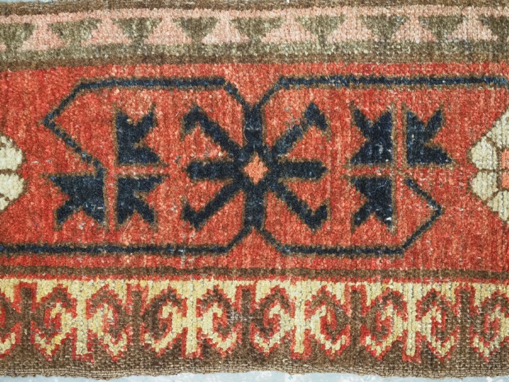 A long, narrow antique Kyrgyz woven wool tegerich fragment featuring geometric star motifs on a deep red background with brown decorative borders. View VIII