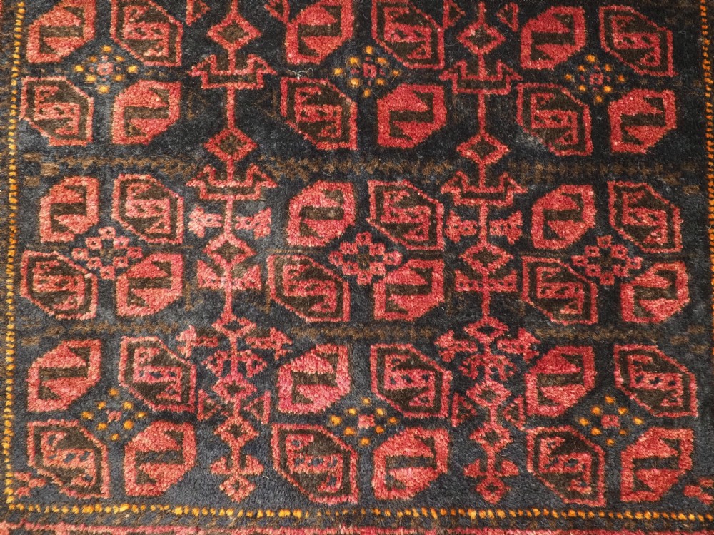 An antique hand-woven Baluch saddle bag face featuring dark red and navy geometric tile patterns with flatwoven web borders. View VI