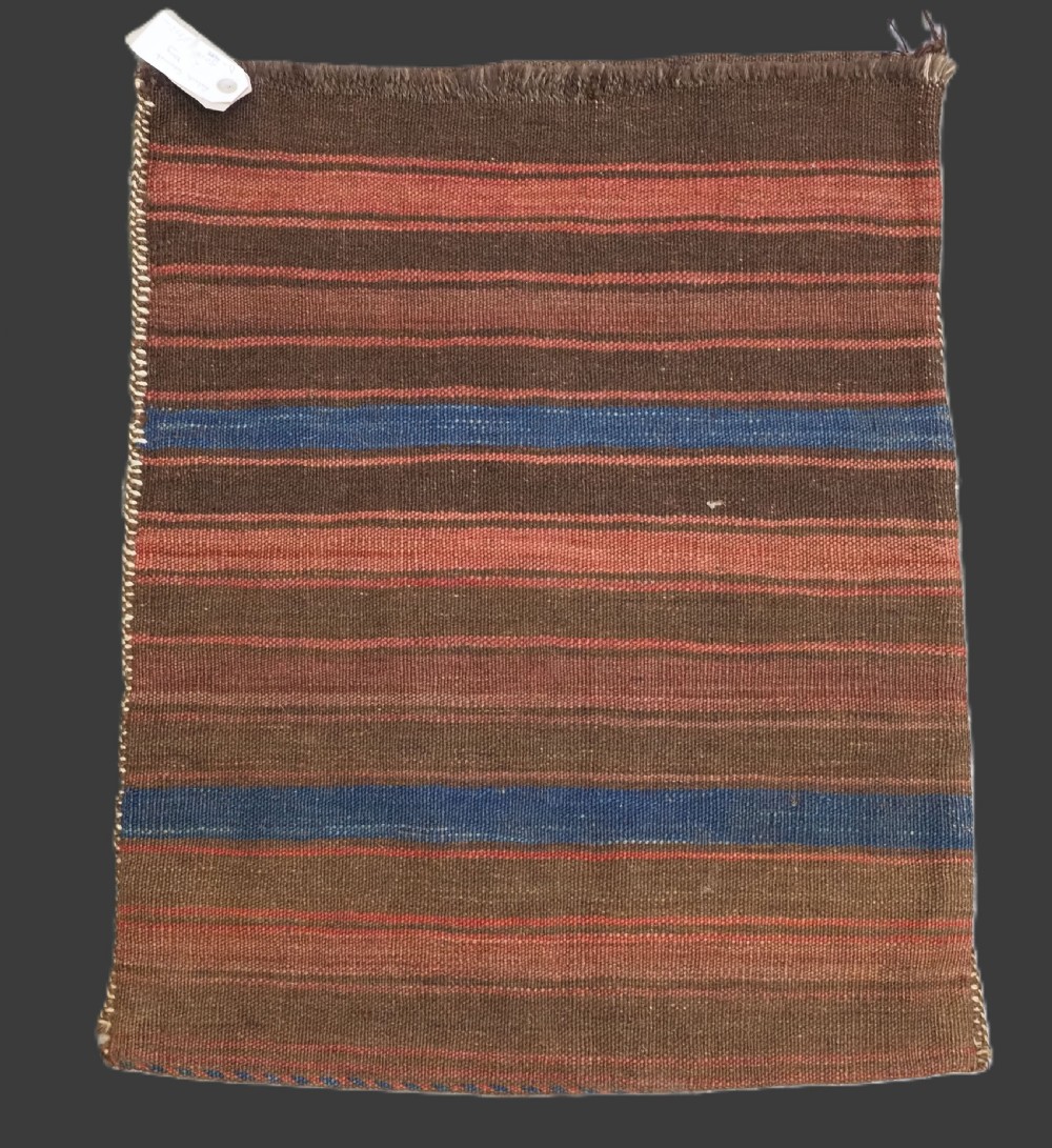 An antique woven Baluch storage bag featuring horizontal bands of geometric diamond motifs in terracotta, indigo blue, and cream wool. View VIII