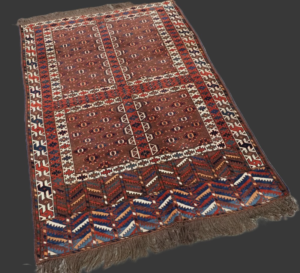 An antique late nineteenth-century Yomut Turkmen Ensi wool rug featuring a cruciform hatchli design in deep red-brown, navy blue, and ivory tones with a double tree elem skirt. View II
