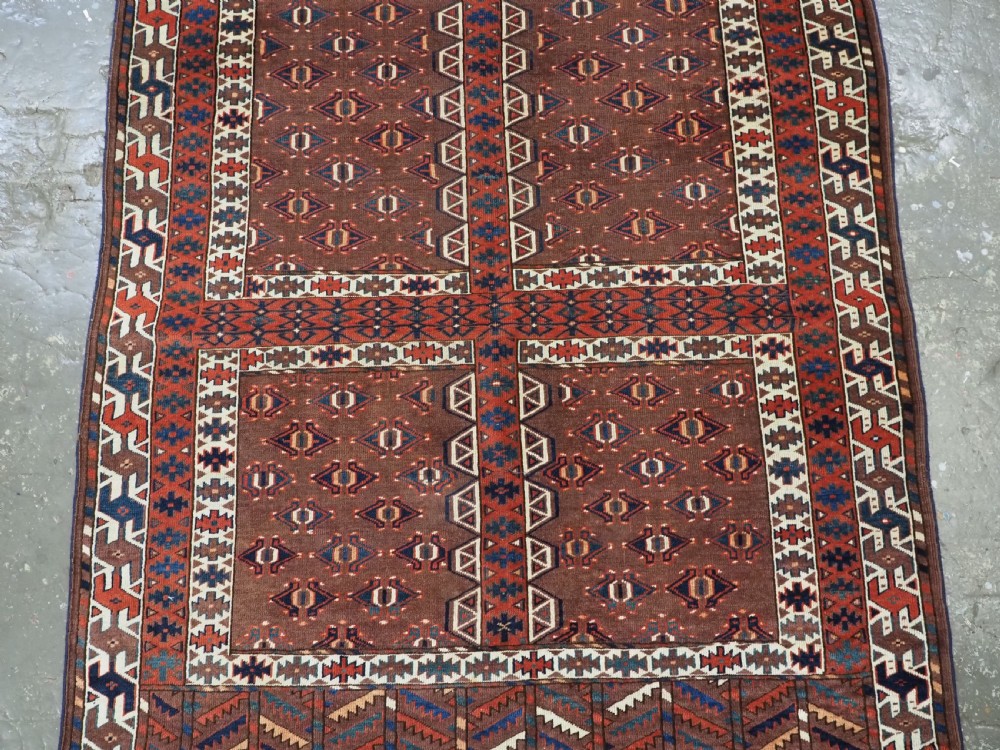 An antique late nineteenth-century Yomut Turkmen Ensi wool rug featuring a cruciform hatchli design in deep red-brown, navy blue, and ivory tones with a double tree elem skirt. View IV