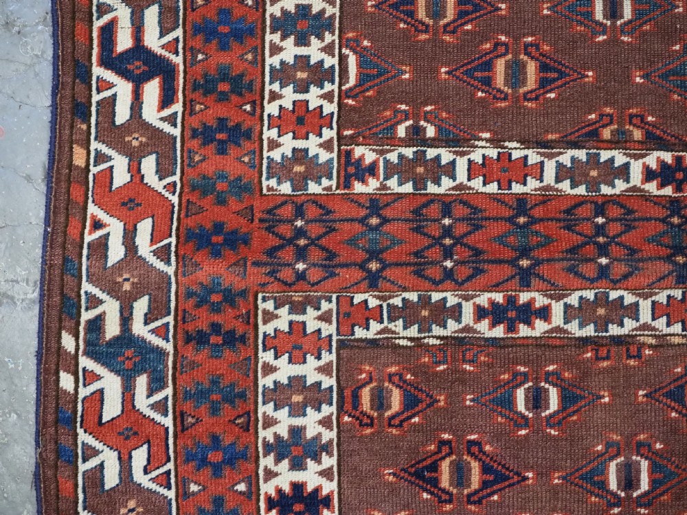 An antique late nineteenth-century Yomut Turkmen Ensi wool rug featuring a cruciform hatchli design in deep red-brown, navy blue, and ivory tones with a double tree elem skirt. View VII