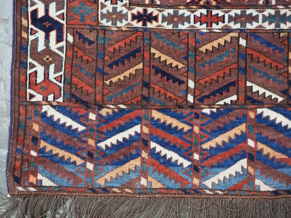 An antique late nineteenth-century Yomut Turkmen Ensi wool rug featuring a cruciform hatchli design in deep red-brown, navy blue, and ivory tones with a double tree elem skirt. View VIII