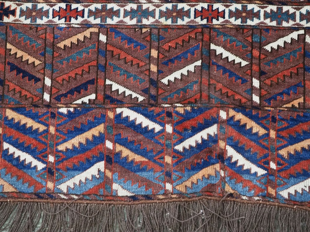 An antique late nineteenth-century Yomut Turkmen Ensi wool rug featuring a cruciform hatchli design in deep red-brown, navy blue, and ivory tones with a double tree elem skirt. View IX