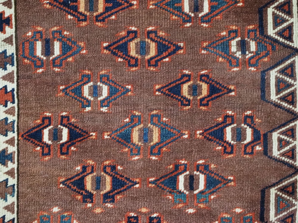 An antique late nineteenth-century Yomut Turkmen Ensi wool rug featuring a cruciform hatchli design in deep red-brown, navy blue, and ivory tones with a double tree elem skirt. View XIII