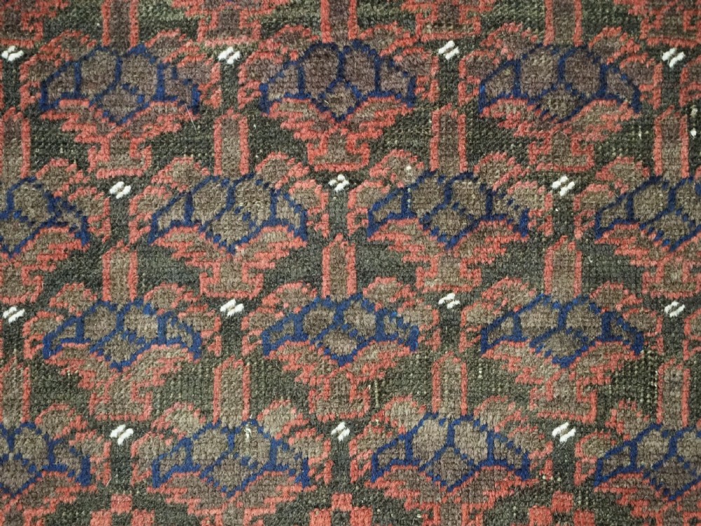 An antique hand-knotted Timuri Baluch wool rug featuring a dark red and brown field with a repeating small shrub design enclosed by geometric borders. View VIII