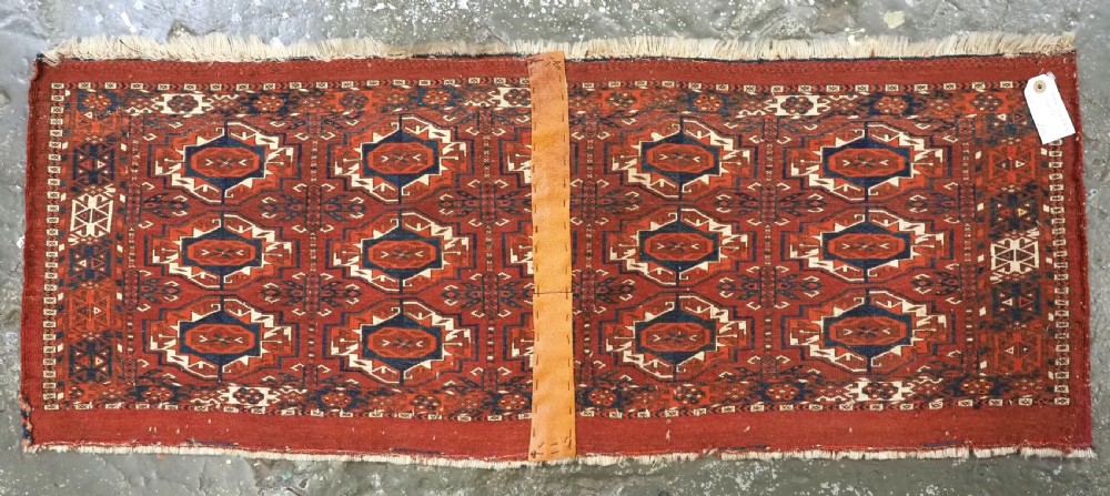 An antique Tekke Turkmen wool torba fragment featuring fifteen repeating octagonal geometric guls in terracotta red, cream, and navy blue. View XII