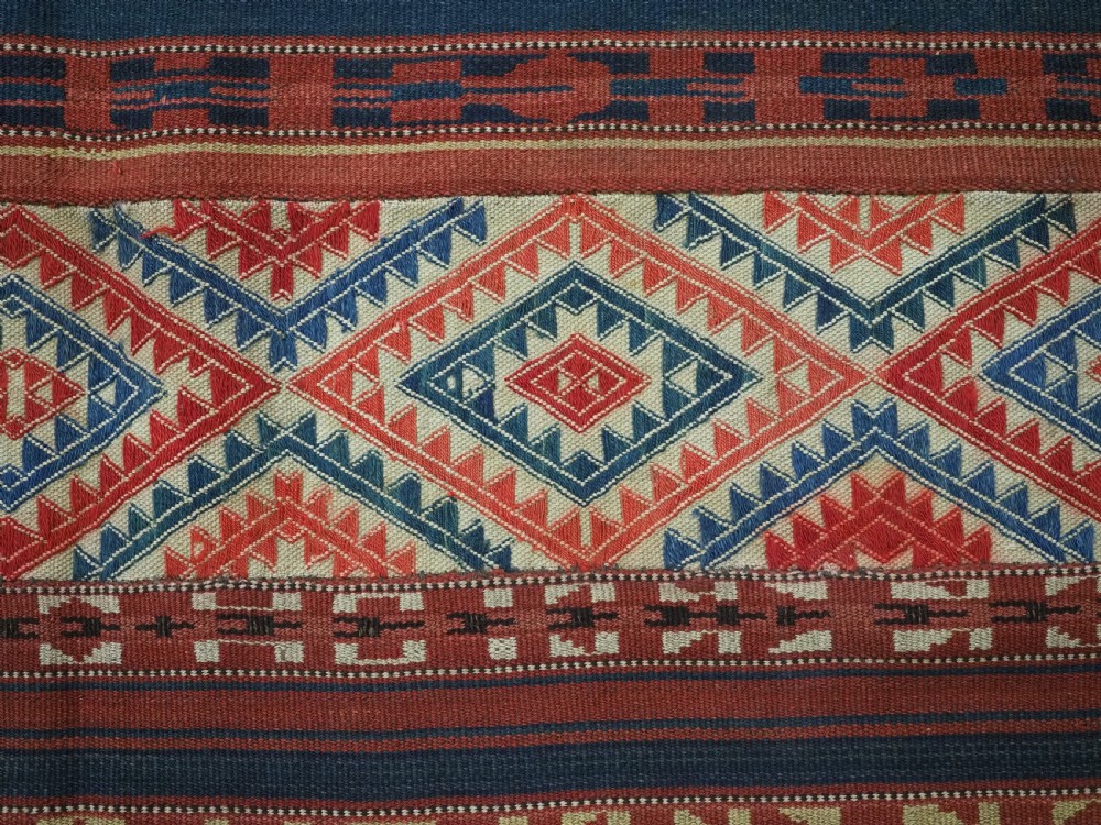 An antique central Asian kilim rug composed of thirteen vertical strips showing geometric diamond and stripe patterns in red, navy blue, and cream. View XIII