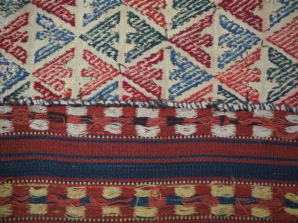 An antique central Asian kilim rug composed of thirteen vertical strips showing geometric diamond and stripe patterns in red, navy blue, and cream. View XV