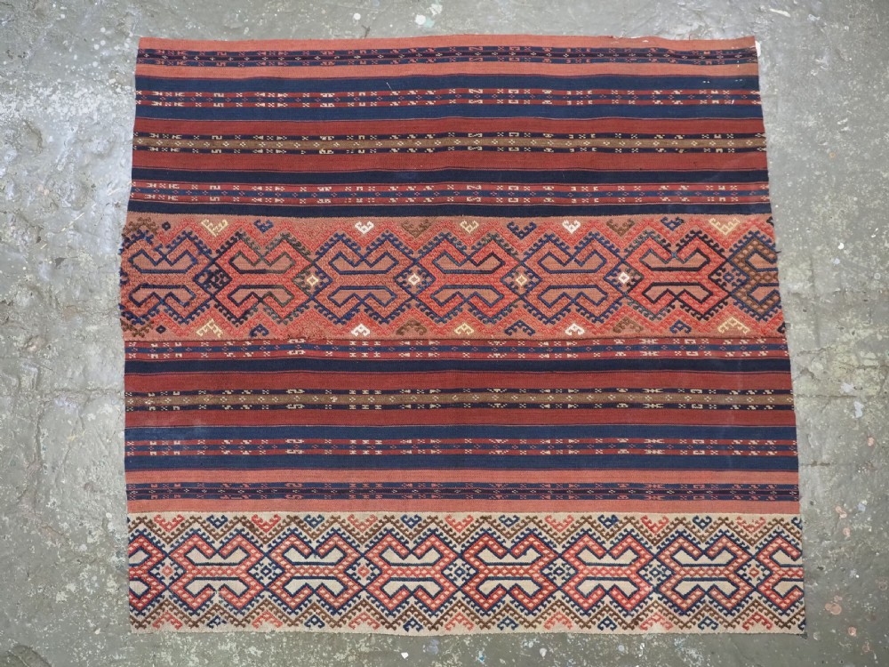 An antique handwoven Uzbek kilim panel constructed from four joined strips featuring terracotta red, indigo blue, and ivory geometric patterns. View II