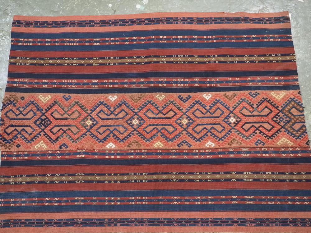 An antique handwoven Uzbek kilim panel constructed from four joined strips featuring terracotta red, indigo blue, and ivory geometric patterns. View V