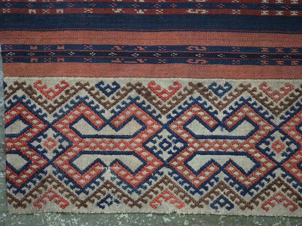 An antique handwoven Uzbek kilim panel constructed from four joined strips featuring terracotta red, indigo blue, and ivory geometric patterns. View VIII