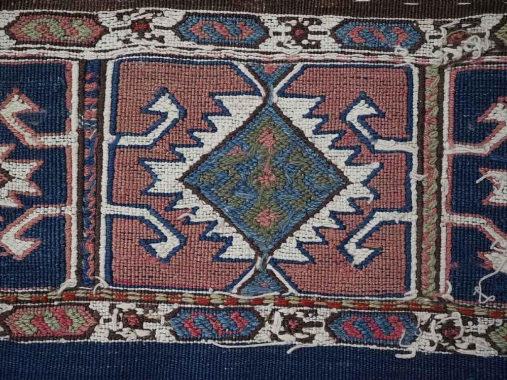 A flatwoven wool Caucasian kilim rug featuring horizontal brown and cream stripes alongside geometric diamond panels in indigo blue, terracotta, and green. View IX