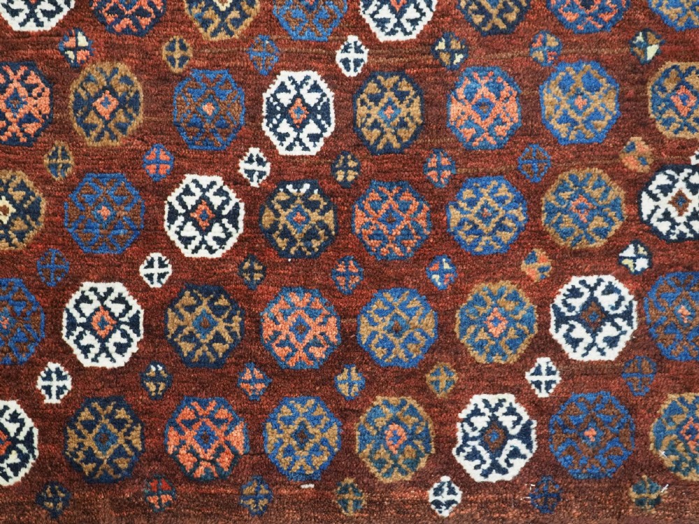 A late 19th-century South Persian hand-woven wool double saddle bag featuring geometric medallions, repeated guls, and stepped diamond patterns in shades of deep red, indigo blue, and ivory. View XI