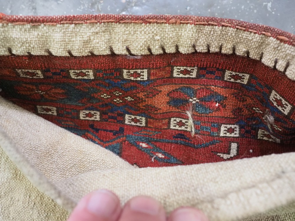 A horizontal handwoven wool Tekke Turkmen torba featuring six octagonal gul medallions on a deep red background with geometric borders and braided side tassels. View XIII