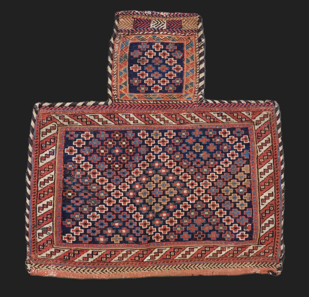 An antique Afshar tribal salt bag featuring a bottleneck neck and wide body woven in dark blue, rust red, and white geometric Soumak patterns.