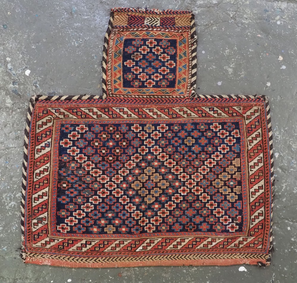 An antique Afshar tribal salt bag featuring a bottleneck neck and wide body woven in dark blue, rust red, and white geometric Soumak patterns. View II