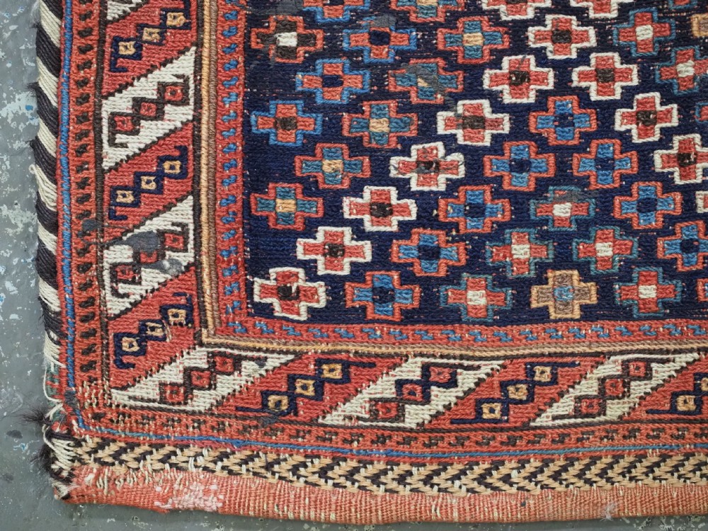 An antique Afshar tribal salt bag featuring a bottleneck neck and wide body woven in dark blue, rust red, and white geometric Soumak patterns. View VII