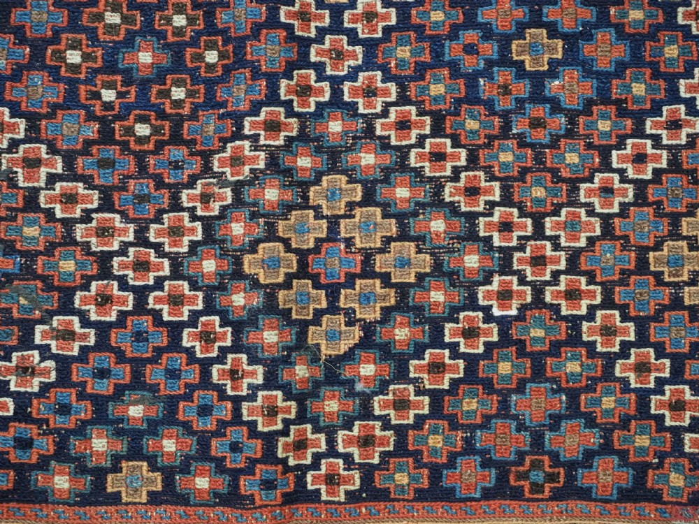 An antique Afshar tribal salt bag featuring a bottleneck neck and wide body woven in dark blue, rust red, and white geometric Soumak patterns. View X