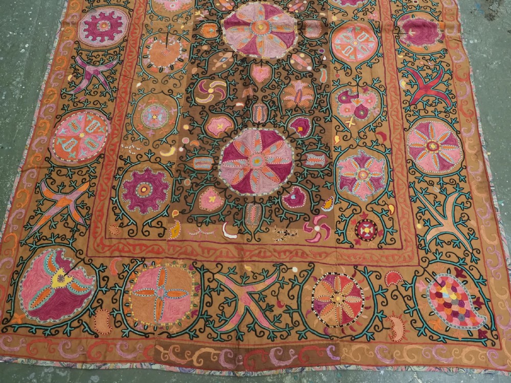 An antique Uzbek Shahrisabz region suzani textile with pink and orange silk embroidered floral medallions on a brown cotton field. View IV