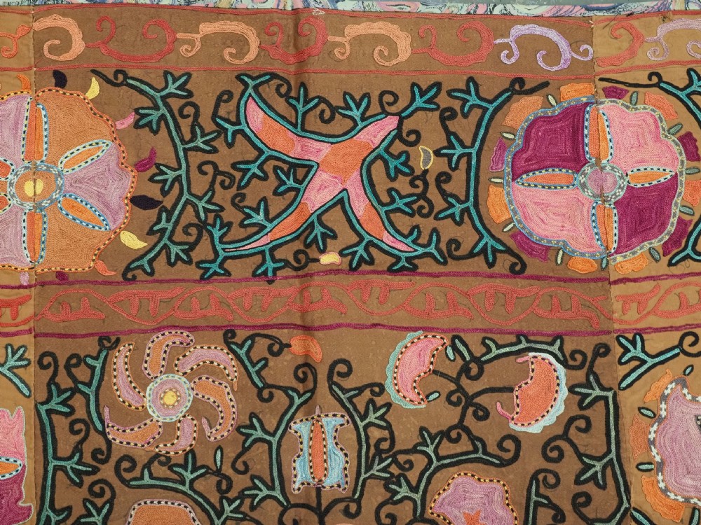 An antique Uzbek Shahrisabz region suzani textile with pink and orange silk embroidered floral medallions on a brown cotton field. View VII