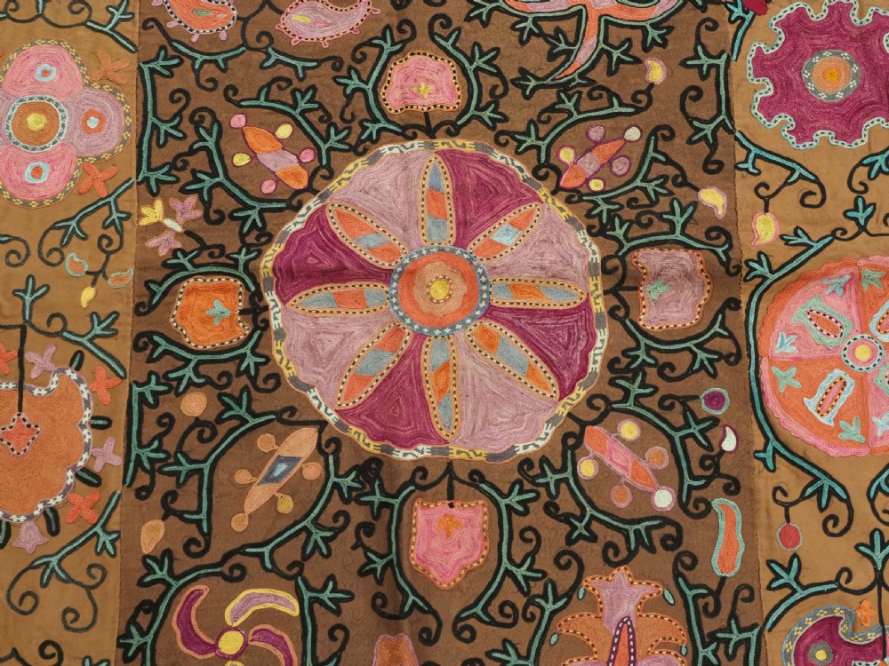 An antique Uzbek Shahrisabz region suzani textile with pink and orange silk embroidered floral medallions on a brown cotton field. View IX