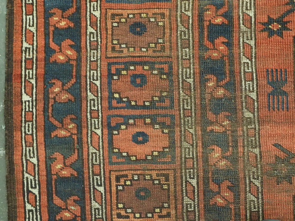 An antique Ersari Turkmen hand-knotted wool carpet displaying repeated octagonal gol motifs on a terracotta field with geometric borders. View VII