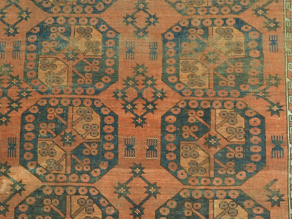 An antique Ersari Turkmen hand-knotted wool carpet displaying repeated octagonal gol motifs on a terracotta field with geometric borders. View XI