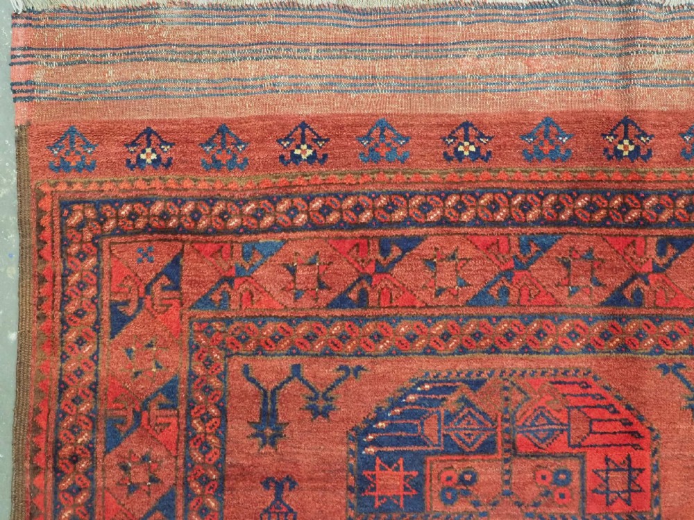 An antique Ersari Turkmen hand-knotted wool main carpet featuring a terracotta red ground filled with dark blue octagonal gul motifs and framed by geometric borders. View VI