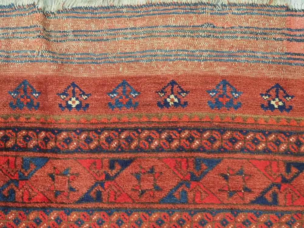An antique Ersari Turkmen hand-knotted wool main carpet featuring a terracotta red ground filled with dark blue octagonal gul motifs and framed by geometric borders. View VII