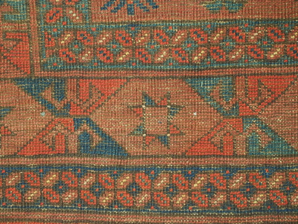 An antique Ersari Turkmen hand-knotted wool main carpet featuring a terracotta red ground filled with dark blue octagonal gul motifs and framed by geometric borders. View X