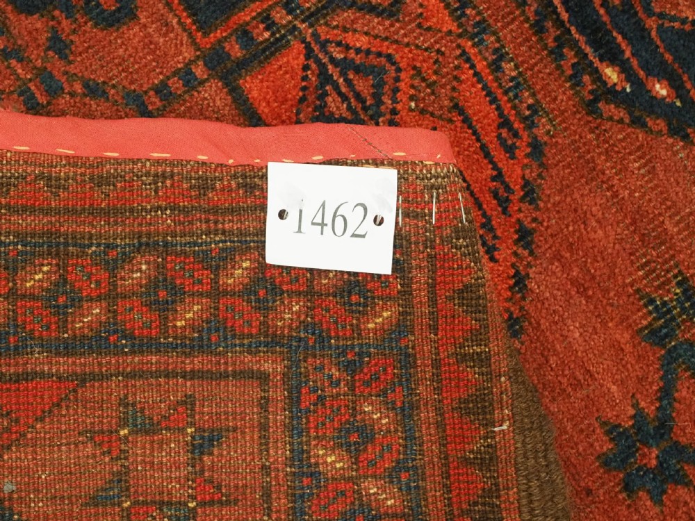 An antique Ersari Turkmen hand-knotted wool main carpet featuring a terracotta red ground filled with dark blue octagonal gul motifs and framed by geometric borders. View XI