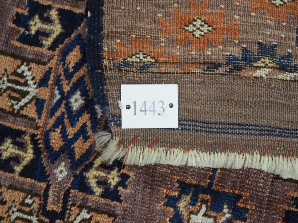 An antique hand-knotted wool carpet featuring repeated diamond-shaped kepse gul motifs across a dark aubergine field, framed by geometric borders. View XIV