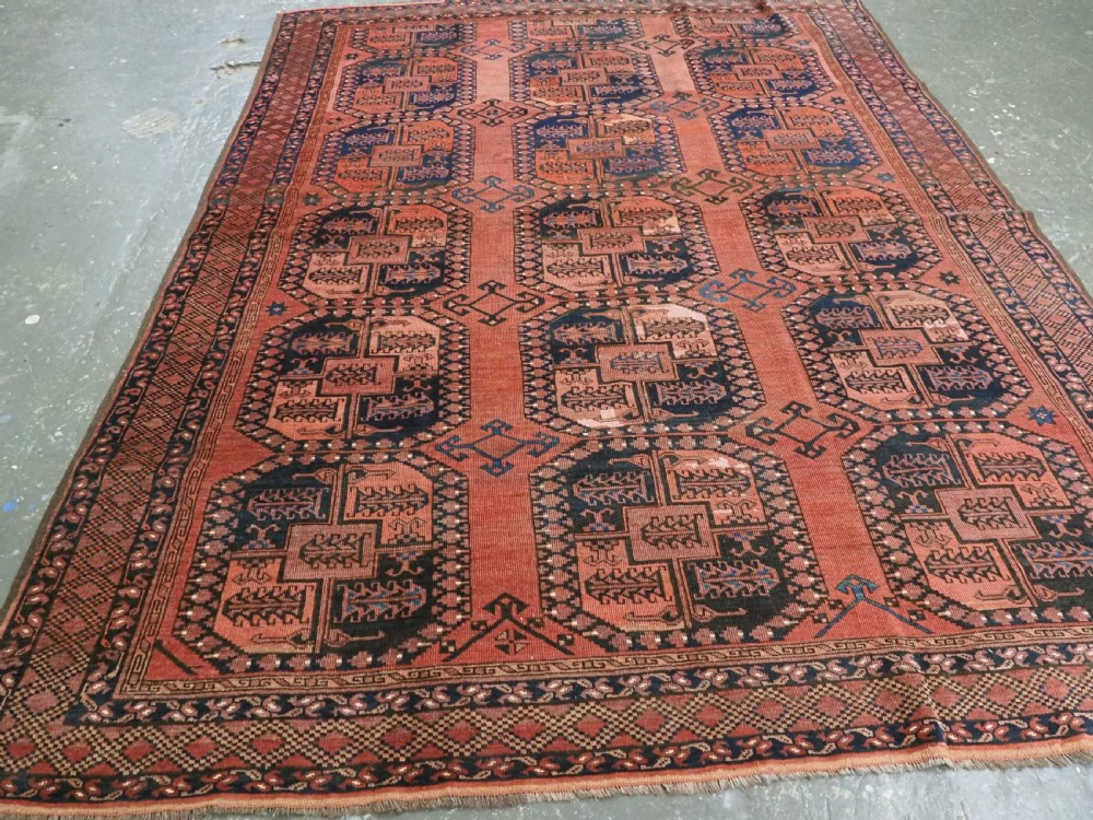 A hand-knotted antique Afghan Ersari Turkmen wool carpet featuring octagonal gul motifs on a rust red ground with geometric borders. View II