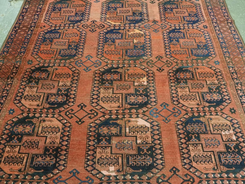 A hand-knotted antique Afghan Ersari Turkmen wool carpet featuring octagonal gul motifs on a rust red ground with geometric borders. View IV