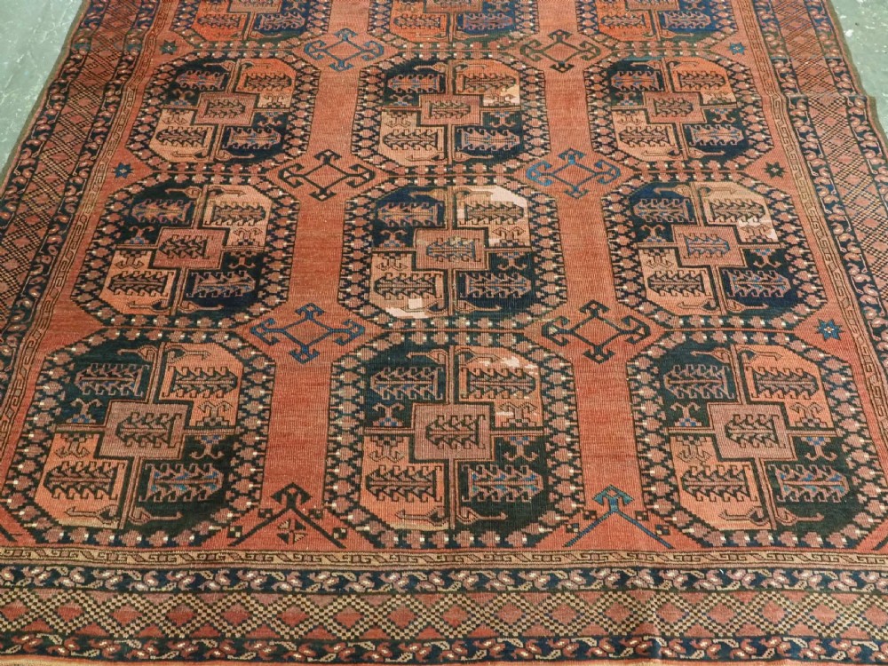 A hand-knotted antique Afghan Ersari Turkmen wool carpet featuring octagonal gul motifs on a rust red ground with geometric borders. View V