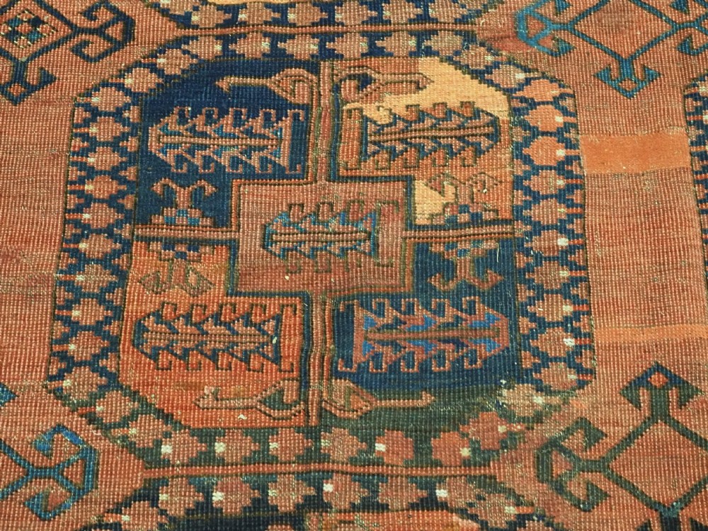 A hand-knotted antique Afghan Ersari Turkmen wool carpet featuring octagonal gul motifs on a rust red ground with geometric borders. View X