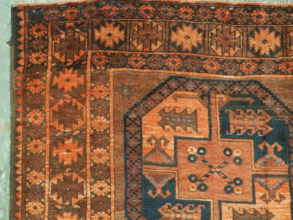 An antique northern Afghan Ersari Turkmen wool carpet featuring repeating octagonal gul motifs in dark blue, beige, and brown set against a deep terracotta red field. View VI