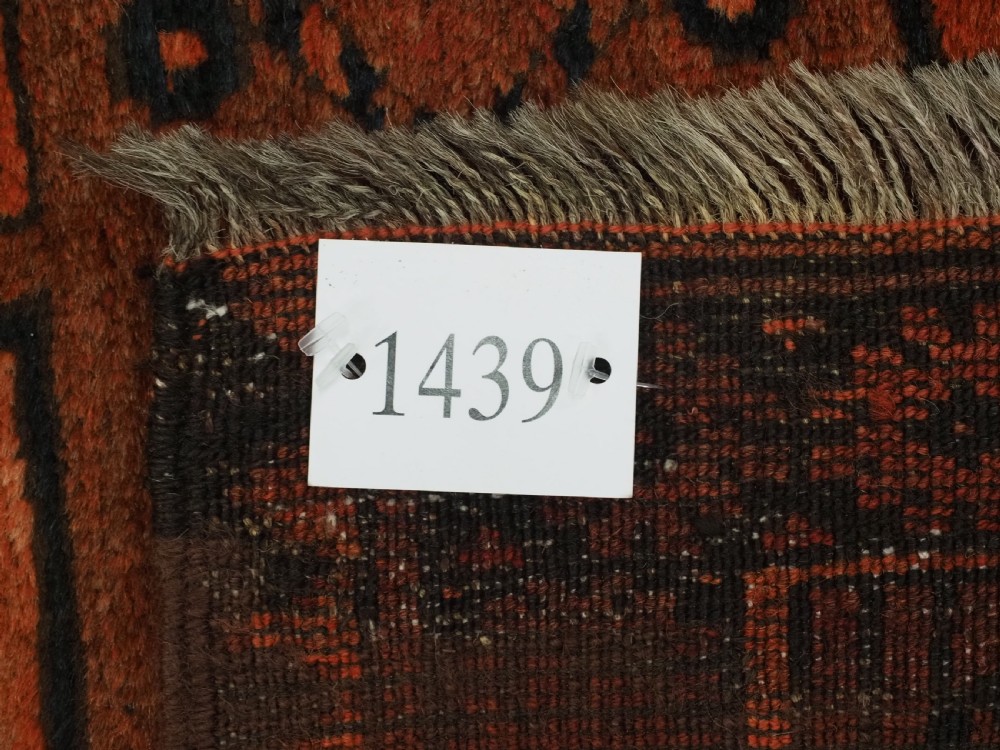 An antique northern Afghan Ersari Turkmen wool carpet featuring repeating octagonal gul motifs in dark blue, beige, and brown set against a deep terracotta red field. View XIII