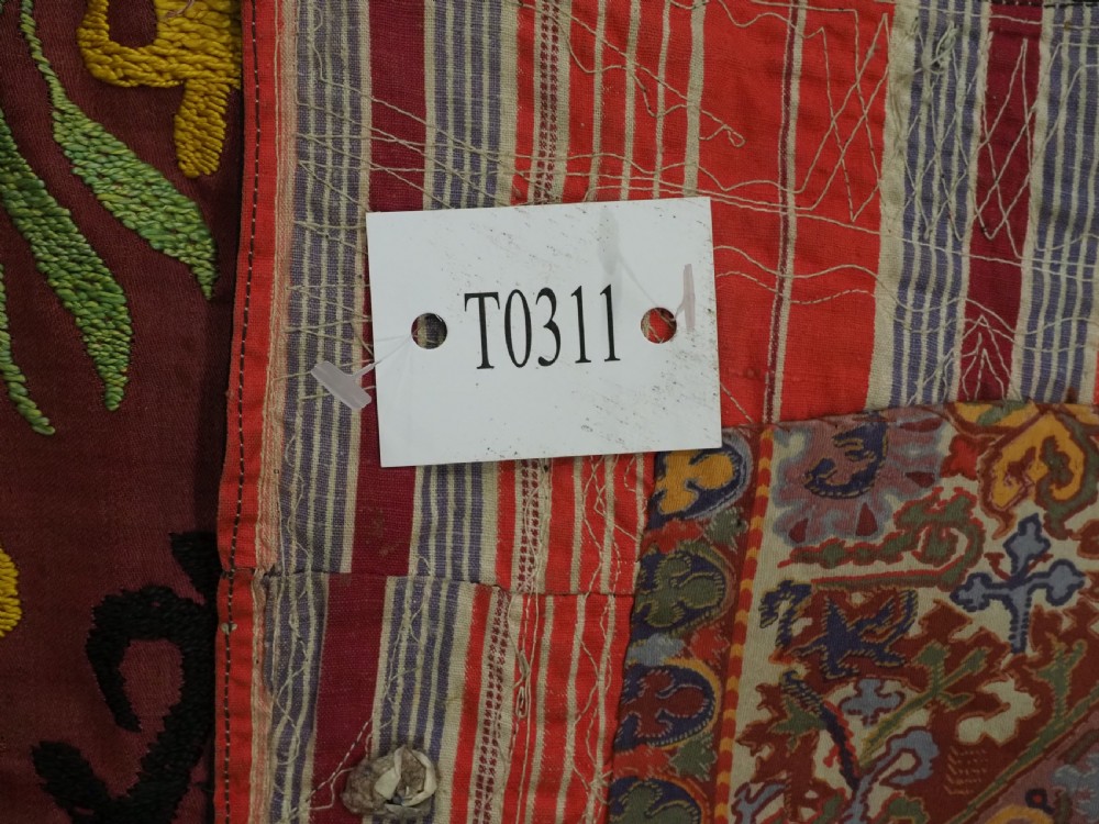 A rectangular hand-embroidered Uzbek suzani textile featuring circular solar medallions with central stars in shades of yellow, purple, white, and red. View XII
