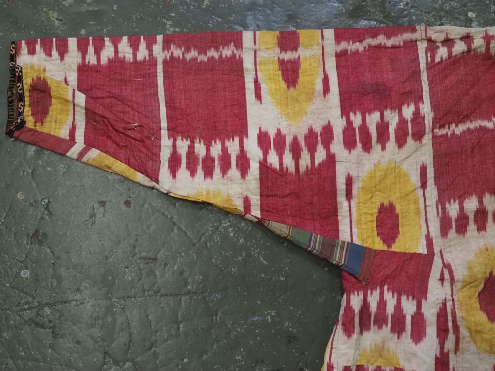 An antique T-shaped Uzbek silk ikat robe featuring geometric motifs in magenta, yellow, and off-white. View II
