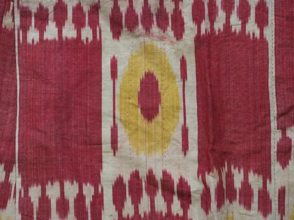 An antique T-shaped Uzbek silk ikat robe featuring geometric motifs in magenta, yellow, and off-white. View VII