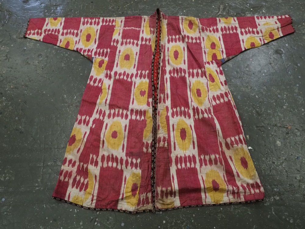 An antique T-shaped Uzbek silk ikat robe featuring geometric motifs in magenta, yellow, and off-white. View VIII