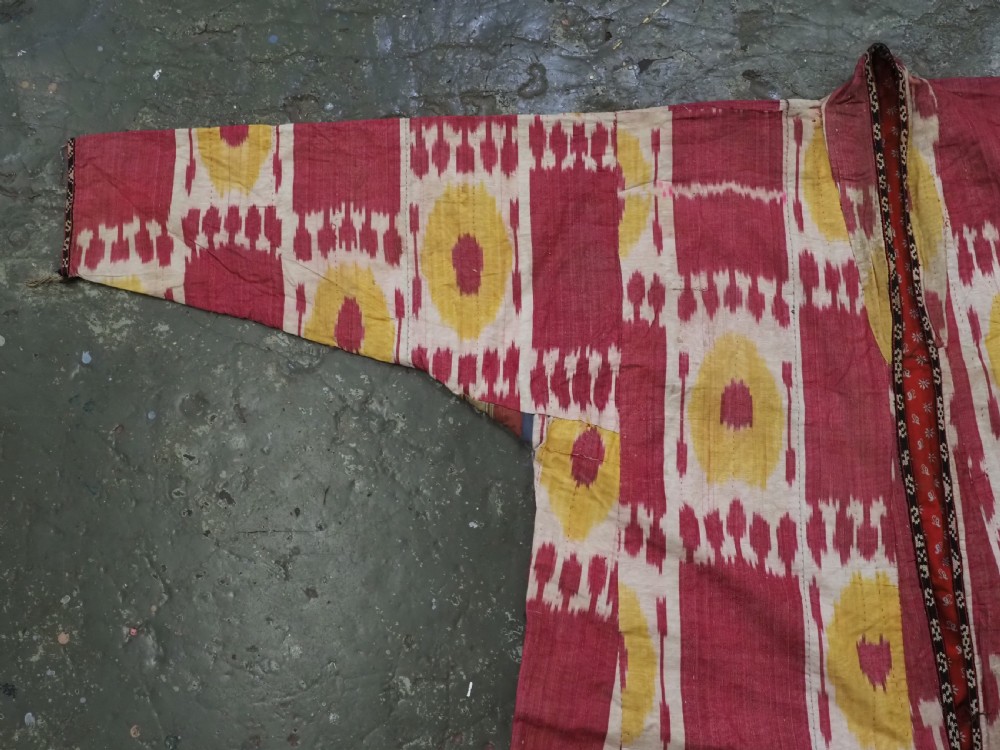 An antique T-shaped Uzbek silk ikat robe featuring geometric motifs in magenta, yellow, and off-white. View IX