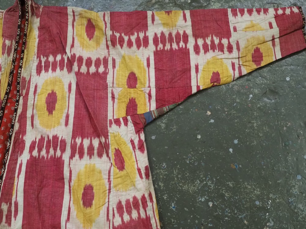 An antique T-shaped Uzbek silk ikat robe featuring geometric motifs in magenta, yellow, and off-white. View XI