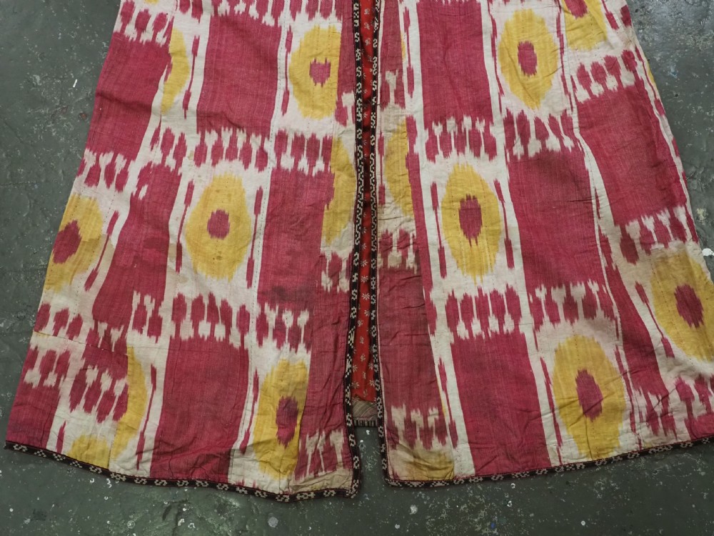 An antique T-shaped Uzbek silk ikat robe featuring geometric motifs in magenta, yellow, and off-white. View XII