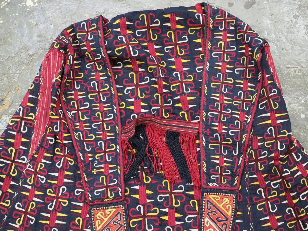 An antique 19th-century Turkmen chyrpy ceremonial coat featuring dense red, yellow, and white silk hand embroidery on a dark base with fringed borders. View II