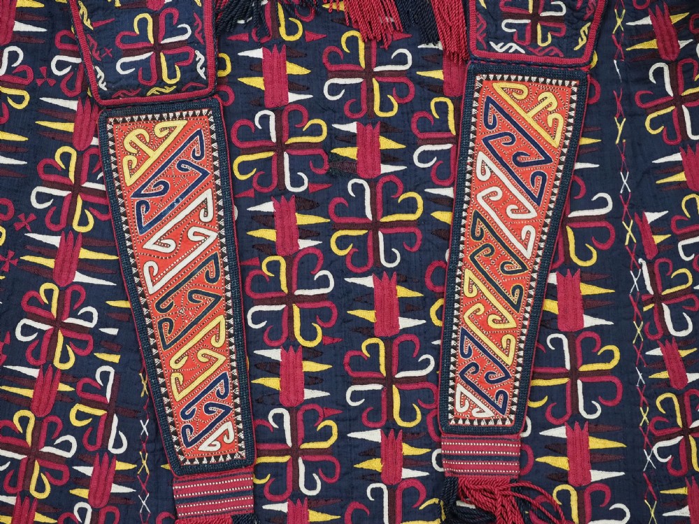 An antique 19th-century Turkmen chyrpy ceremonial coat featuring dense red, yellow, and white silk hand embroidery on a dark base with fringed borders. View III